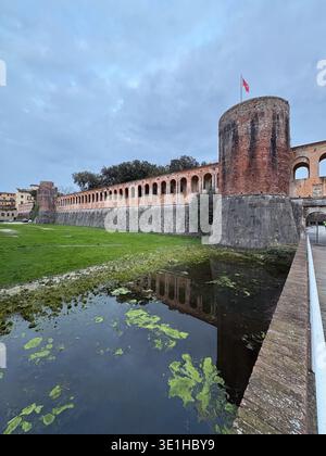 Fortezza Nuova, Pisa Fortress. Renaissance military architecture reflecting in the algae-covered moat under a cloudy sky. Stock Photo