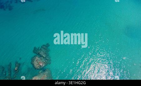 Clear turquoise water with underwater rocks seen from aerial drone perspective Stock Photo