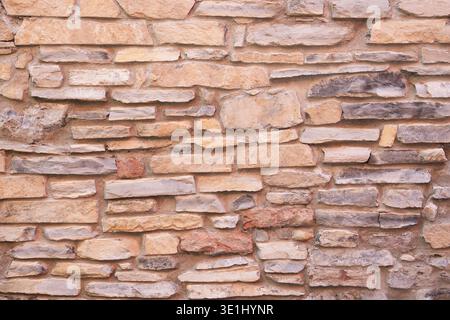 The beige sandstone brick masonry wall texture rustic old background facade Stock Photo