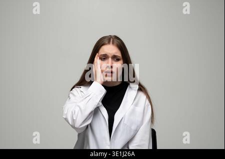 Young woman experiencing stress and anxiety, suffering from a headache, feeling unwell, and needing relief Stock Photo