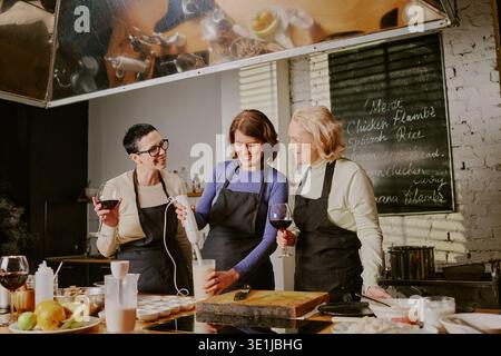 Three Middle Aged Caucasian Women Attending Cooking Class and Preparing Food Stock Photo
