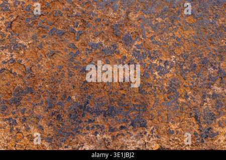 Detailed view of rough steel texture showcasing rust and erosion in an outdoor environment. The weathered surface reflects the passage of time and natural elements. Stock Photo