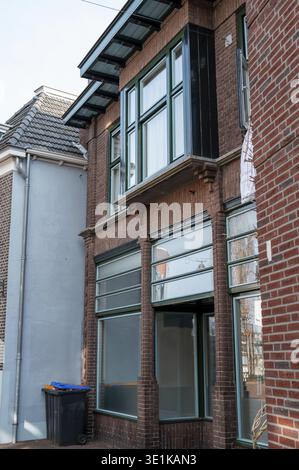 Winterswijk, Gelderland, Netherlands, Brick building featuring green wood window frames and a bay window Stock Photo