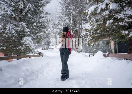 Young woman on snow path at San Domenico ski resort, Italian Alps Stock Photo