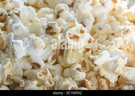 Close-up background of freshly popped popcorn, showing detailed kernels and fluffy shapes, ideal as a snack food concept for cinema, entertainment, TV Stock Photo