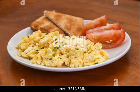Scrambled Eggs with Toast and Tomato on a Plate Stock Photo