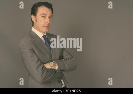 Studio shot of mature handsome businessman against gray background Stock Photo