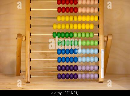 Colorful beads on wooden frame for children inside table interior room Stock Photo