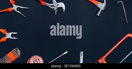 Flat lay of various hand tools forming a frame on a dark background with copy space Stock Photo
