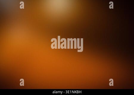 Abstract blurred background with warm tones of orange and brown, creating a soft gradient effect suitable for various design applications and artistic Stock Photo
