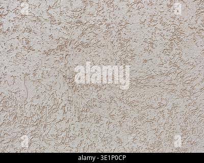 Close up detail of a building façade with decorative beige plaster. The neutral, light brown surface has an abstract bark beetle texture. Minimalist b Stock Photo