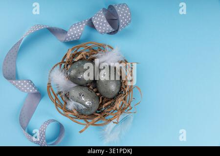 Decorative Easter eggs with silver speckles in nest Stock Photo