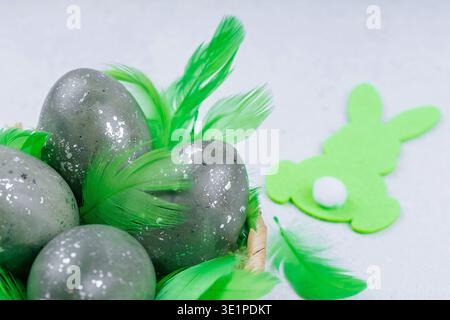 Decorative easter eggs with green feathers and bunny symbol Stock Photo