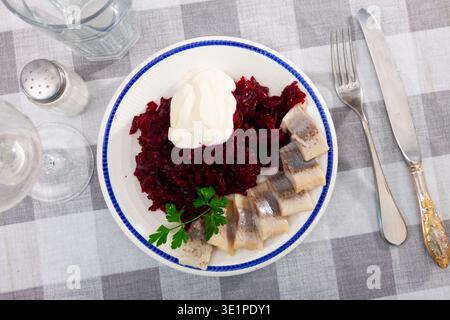 Slightly salted herring with grated beets, greens and mayonnaise Stock Photo