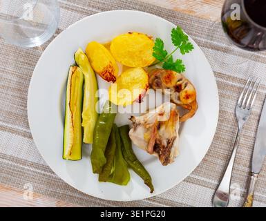 Rabbit meat with vegetables served on plate Stock Photo