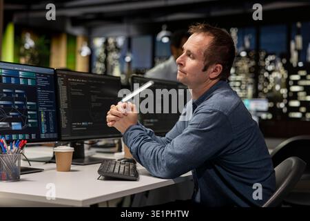 Startup software developer writing code on PC, leveraging AI tech to gain competitive edge. Worker using artificial intelligence coding script on computer, working on technological advancements Stock Photo