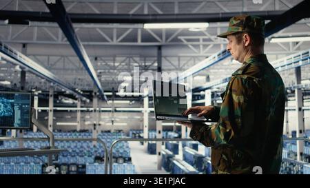 Army expert in data center integrating AI machine learning into radar systems for missile tracking. Military soldier in server farm analyzing aerial movement through neural networks systems, camera A Stock Photo