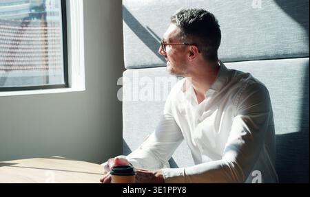 Mature, businessman and thinking with coffee in booth for company ambition, inspiration or vision. Thoughtful, man or contemplating with caffeine or Stock Photo