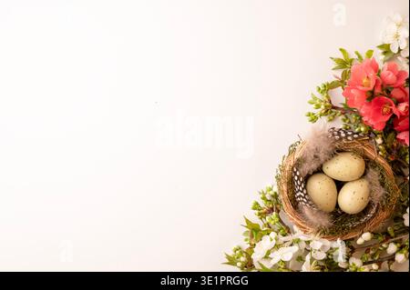 A bird nest sits on a surface with three speckled eggs inside. Surrounding the nest are colorful flowers and green leaves. The scene shows spring with Stock Photo