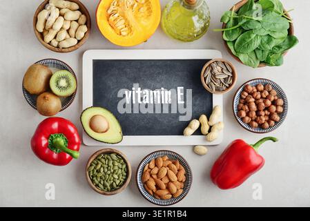 Healthy foods containing vitamin E (Tocopherolum). Natural sources of vitamin E on a light background with chalkboard, top view. Stock Photo