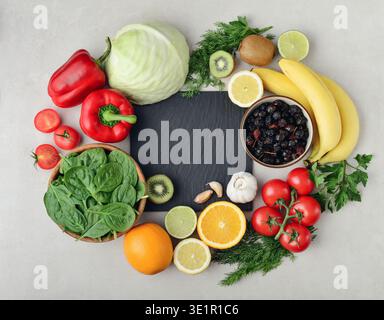 Healthy foods containing vitamin C (Ascorbic acid). Natural sources of vitamin C on a light background with chalkboard, top view. Stock Photo