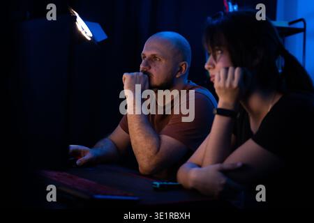 Concentrated Couple Working at Night Stock Photo
