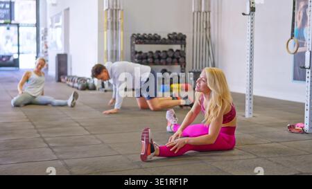 Active people doing stretching exercises for flexibility in gym Stock Photo