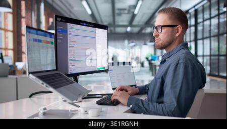 Young Professional Managing Cloud-Based ERP Software On Laptop For Business Optimization Stock Photo