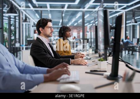 Diverse Team Of Support Agents Answering Calls And Helping Customers Remotely. Customer Service Workers Using Headsets Stock Photo