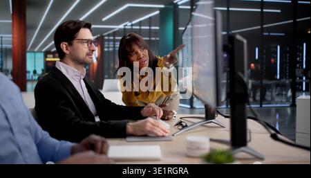 Diverse Team Of Healthcare Analysts And Managers Review Medical Reports Together. Using Computers And Software Stock Photo