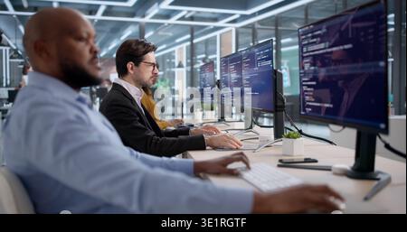 Diverse Team Of Software Engineers Coding Security Programs In An Office. People Developing Computer Systems Stock Photo