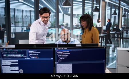 Diverse Team Of Developers Coding Software Projects On Desktop Computers In Office Stock Photo