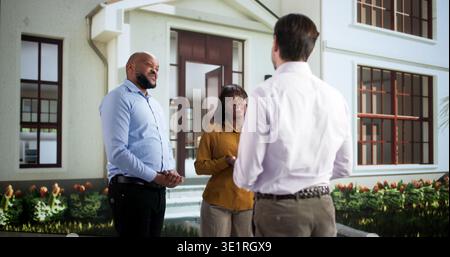 Friendly Neighbors Share Smiles While Exchanging Stories In The Community. African Couple Welcomes New Neighbor Stock Photo