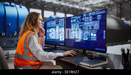 Female Engineer Monitors SCADA System In Oil And Gas Plant. Stock Photo