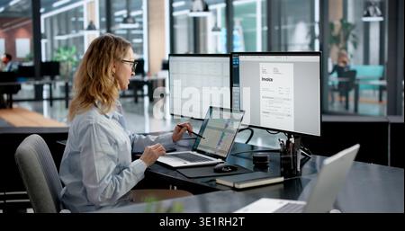 Accountant Creating Invoices On Monitor In Medical Office Using Computer. Business Woman Coding Financial Data Stock Photo