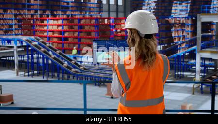 Analyzing Inventory Data On Tablet Dashboard In Warehouse Automation Center Stock Photo