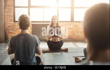 Group of people practicing yoga with instructor Stock Photo