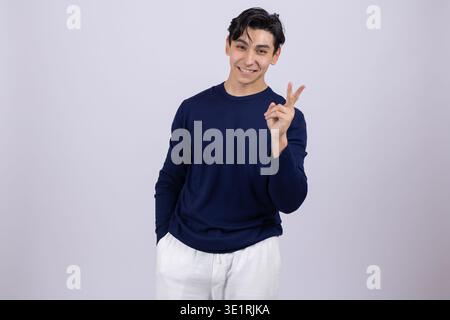 Young man showing victory sign with fingers posing Stock Photo