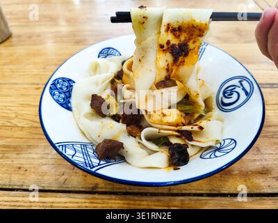 Biangbiang noodles in Xian, Shaanxi, China. Biang biang mian, Chinese Shaanxi cuisine served in Xian Stock Photo