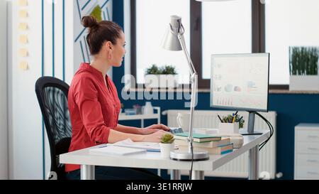 Company assistant analyzing business charts and graphs, looking at financial statistics on computer. Sales consultant using marketing data research to create executive report. Stock Photo