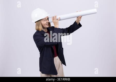 Female architect looking through rolled blueprint Stock Photo