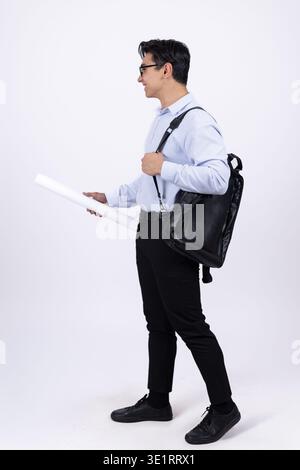 Man with backpack and rolled paper walking Stock Photo