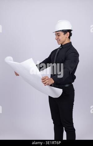 Professional engineer holding building plan and looking Stock Photo