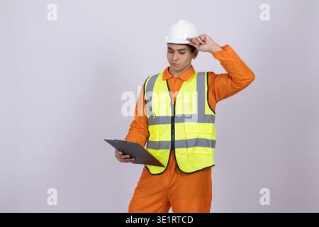 Worker in safety helmet touching his head thinking Stock Photo