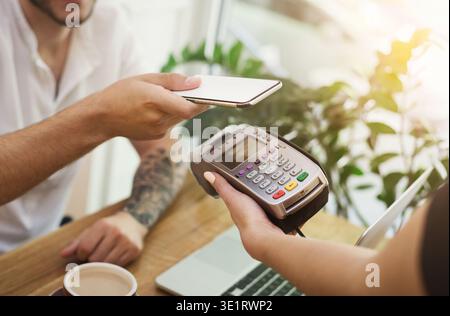 Man paying bill through smartphone using NFC technology Stock Photo