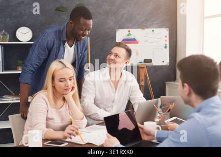 Company coworkers discussing ideas in office Stock Photo
