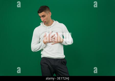Close-up photo of a young Indian man in an office, holding a napkin and feeling unwell. High quality photo Stock Photo