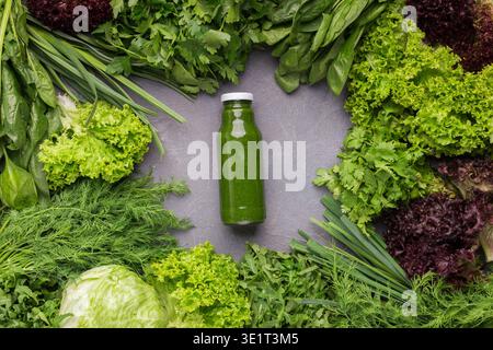 Blended green smoothie with ingredients on kitchen table Stock Photo