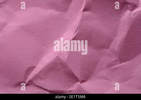 Waves of crumpled pink paper form a soft, textured background with depth and intrigue. Stock Photo