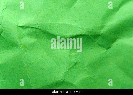 Crumpled green paper showcases unique textures and vibrant hues, creating art. Stock Photo